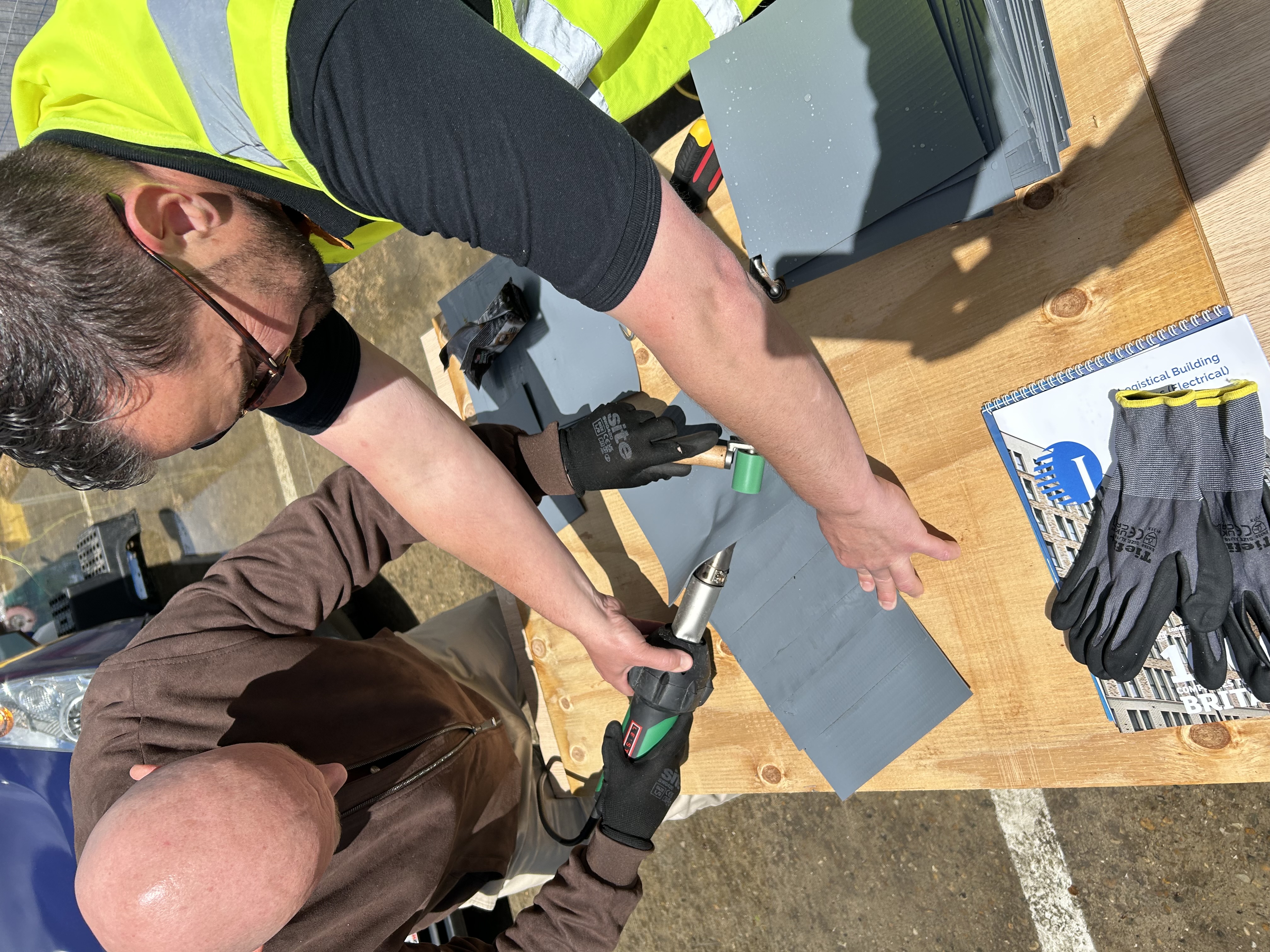 Bauder site technician David Veiga instructing an attendee on single ply flat roofing techniques