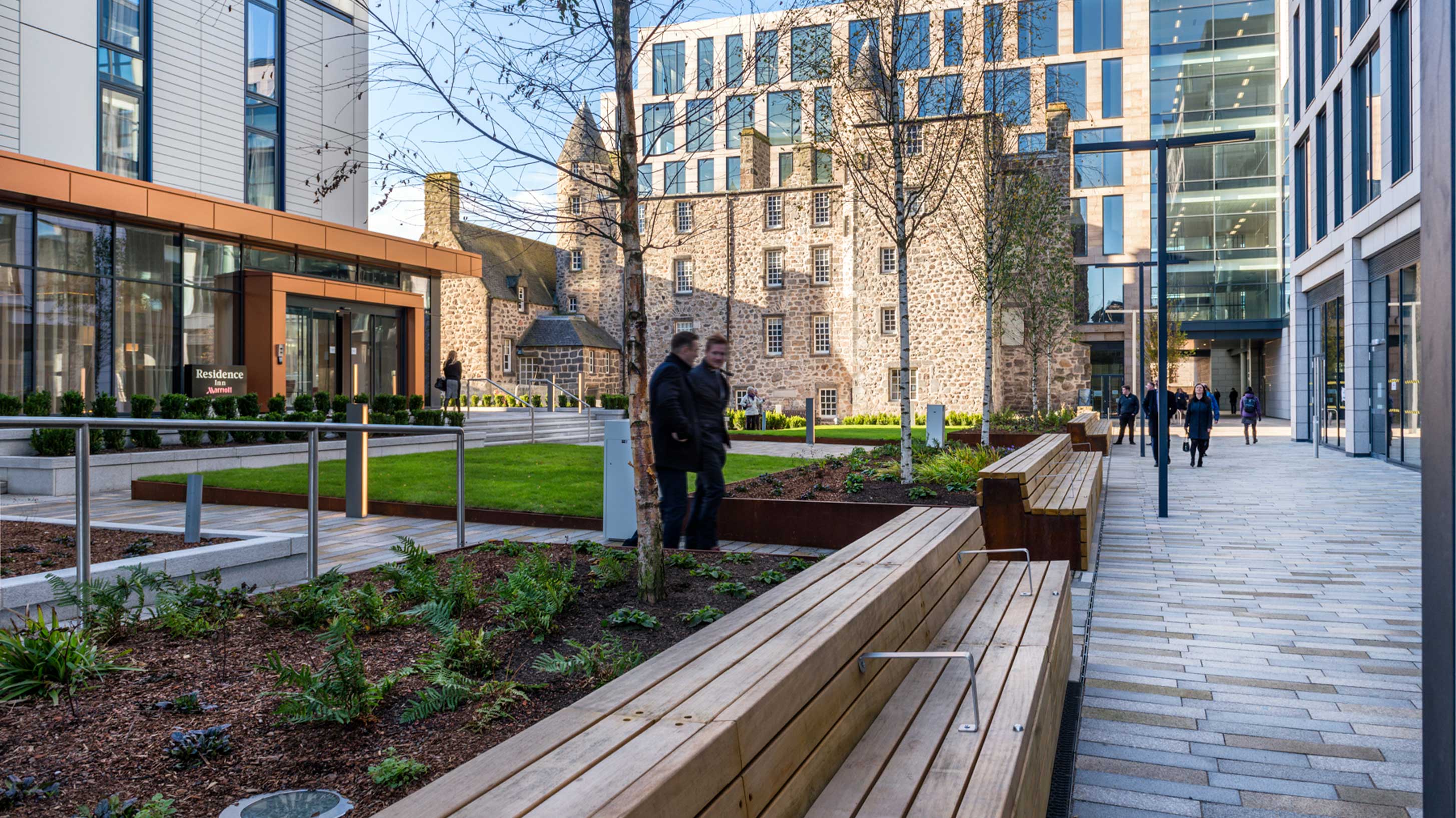 two gentlemen walking in Marischal-Square, a modern building in Aberdeen