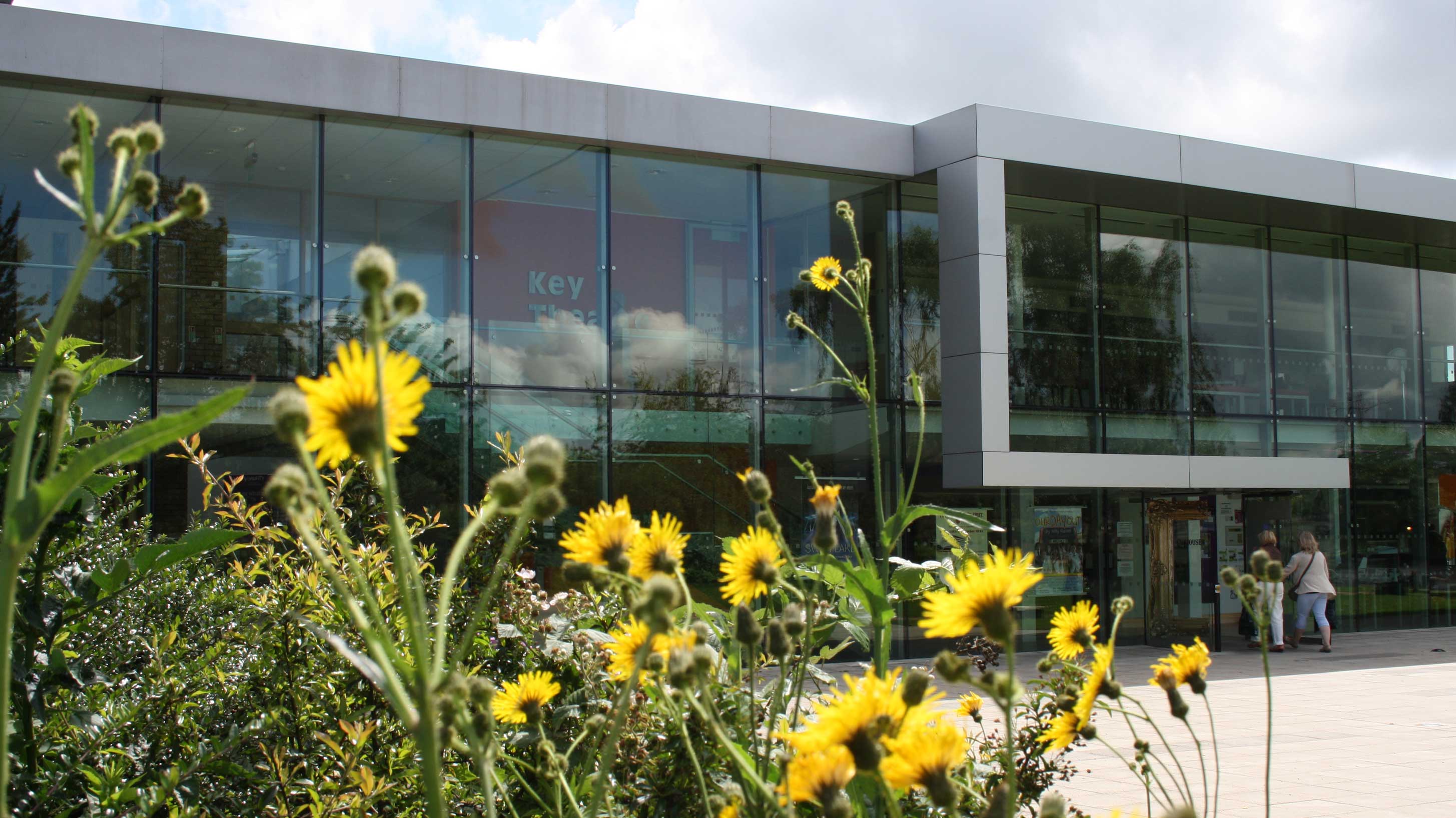 Key Theatre, a modern building with wildflowers in the foreground