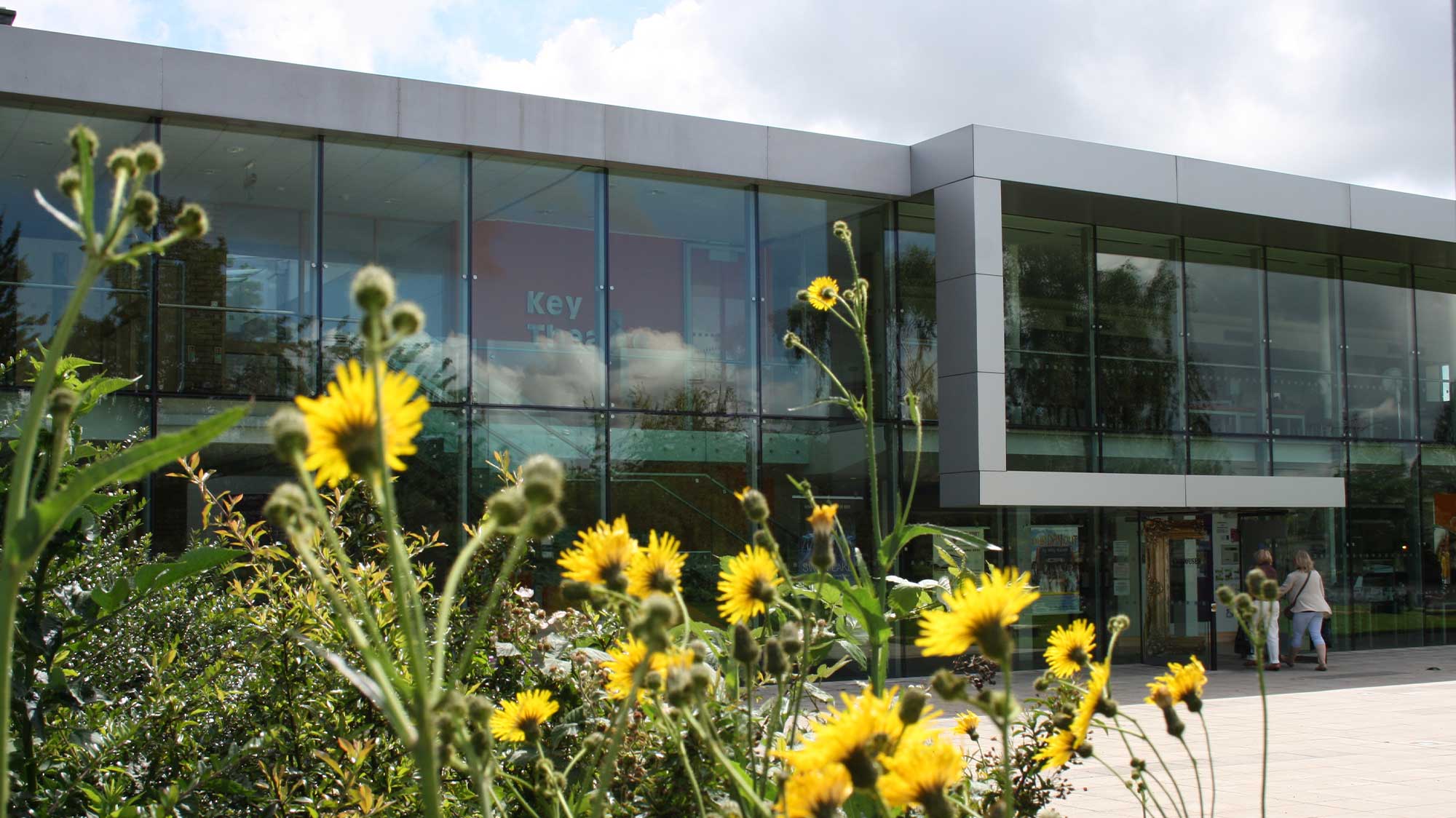 Key Theatre, a modern building with wildflowers in the foreground