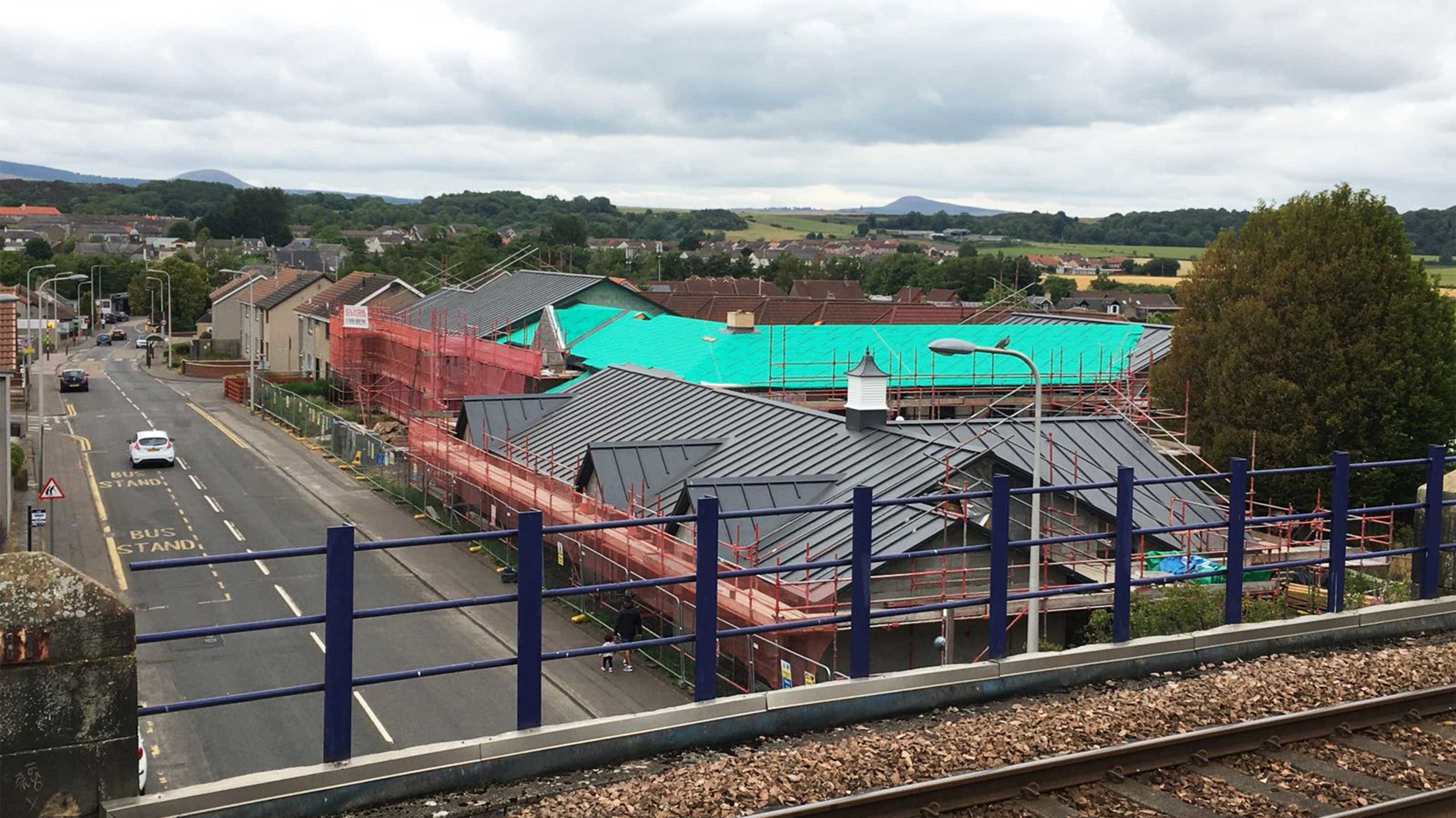 Landscape overview of Den Court with scaffolding attached
