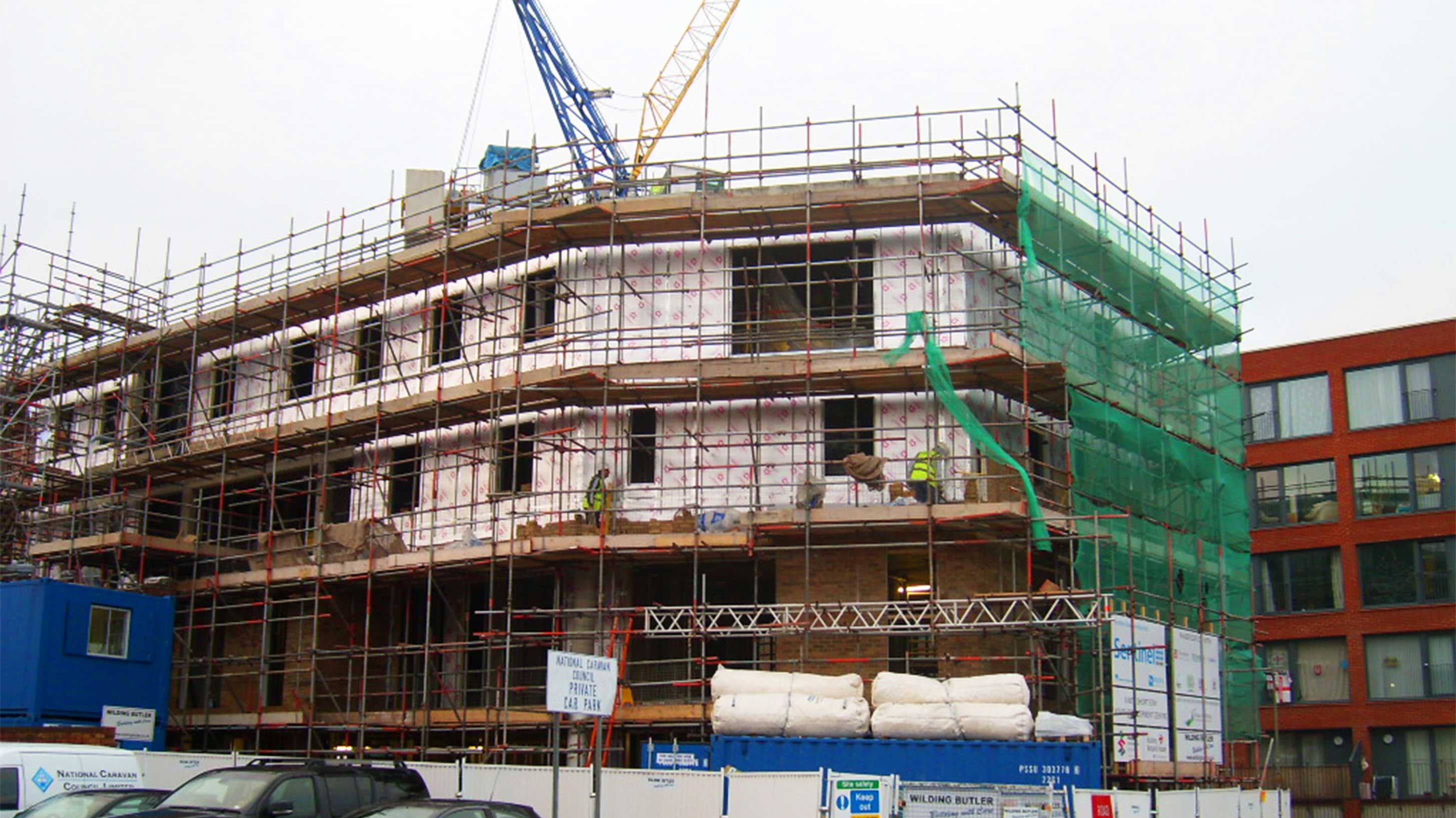 Old building in restoration process surrounded by scaffolding & netting
