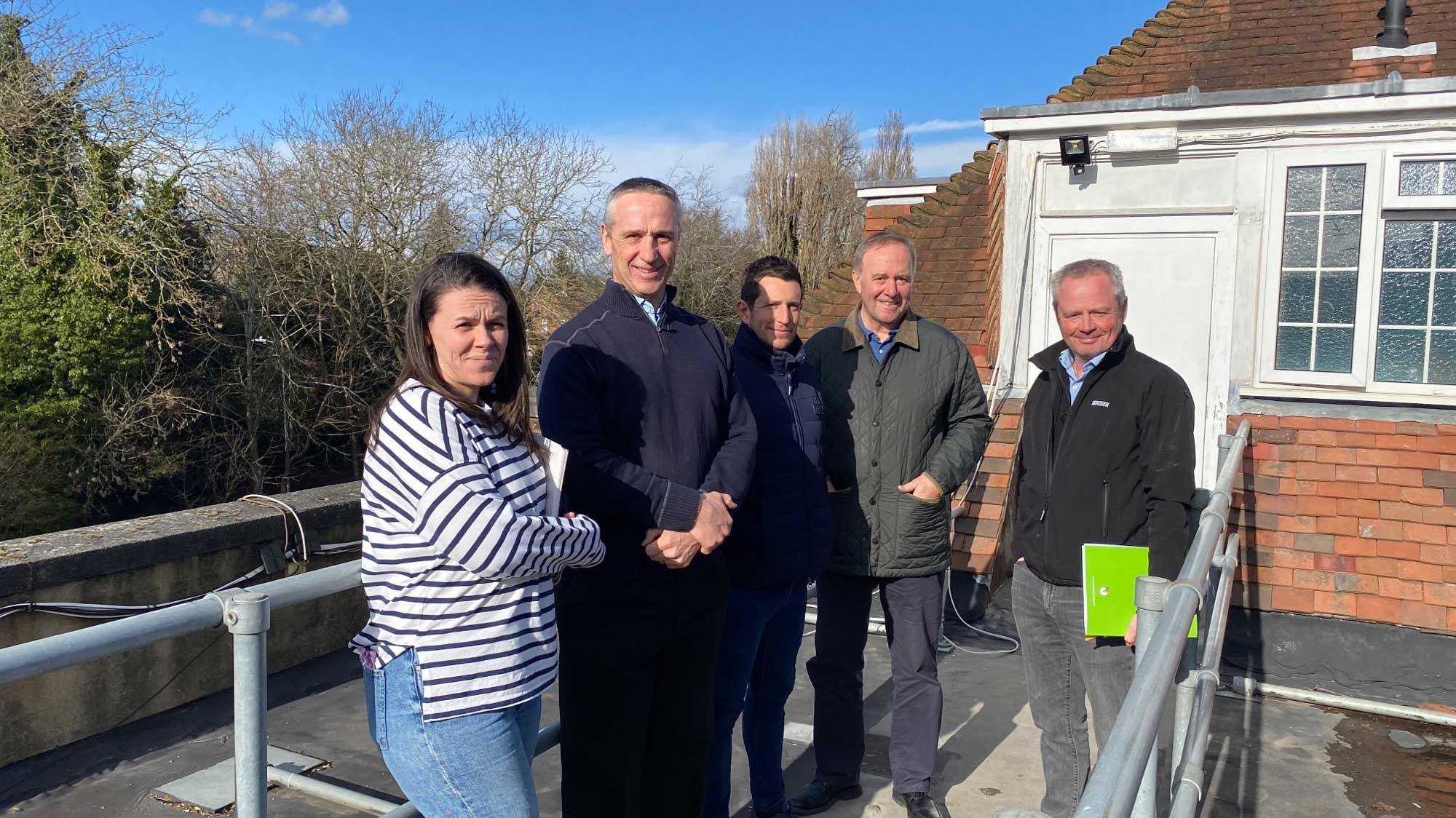 5 people on a rooftop following a roofing solution