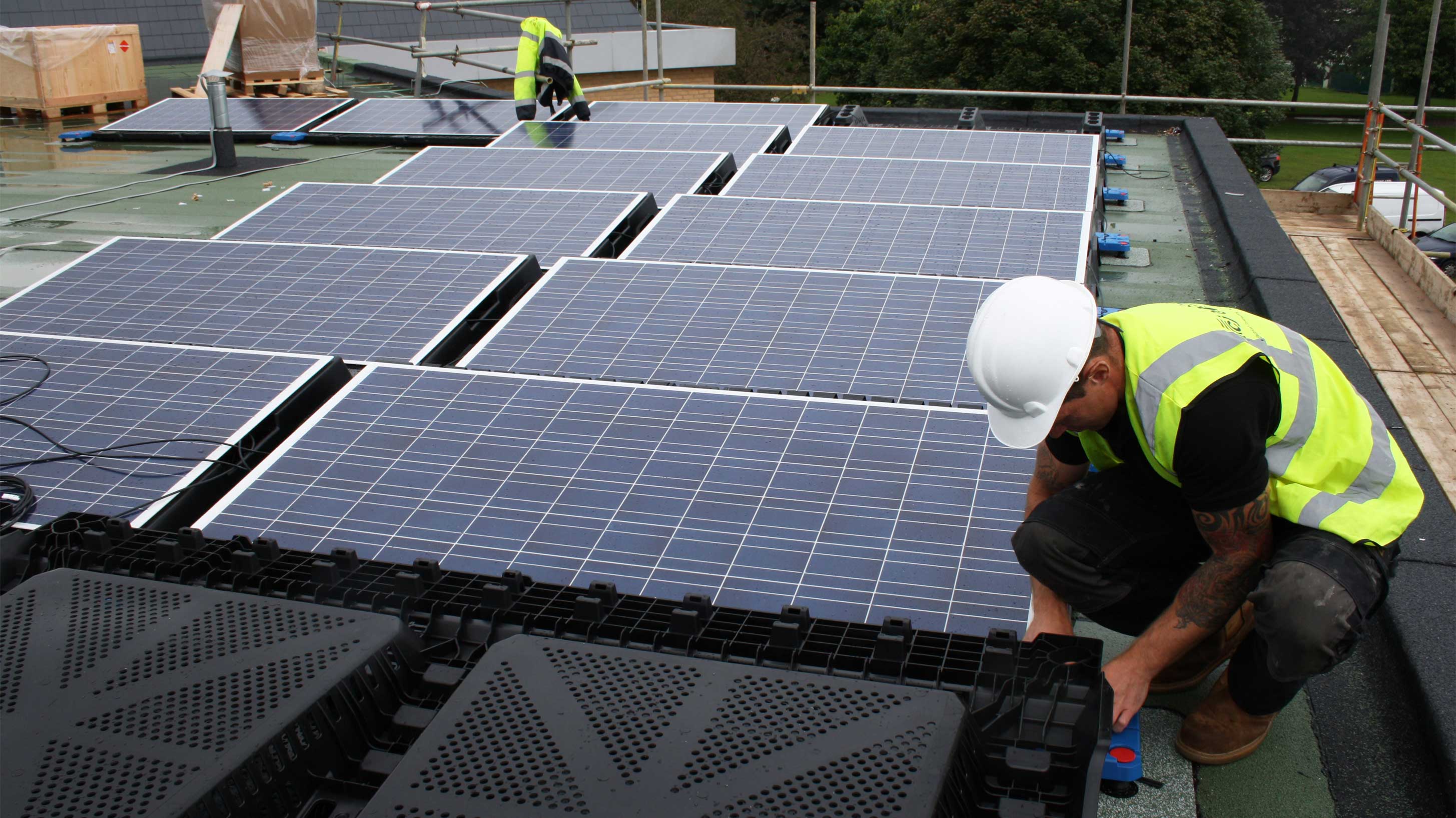 Key Theatre, a modern building with solar panels being fitted on its roof