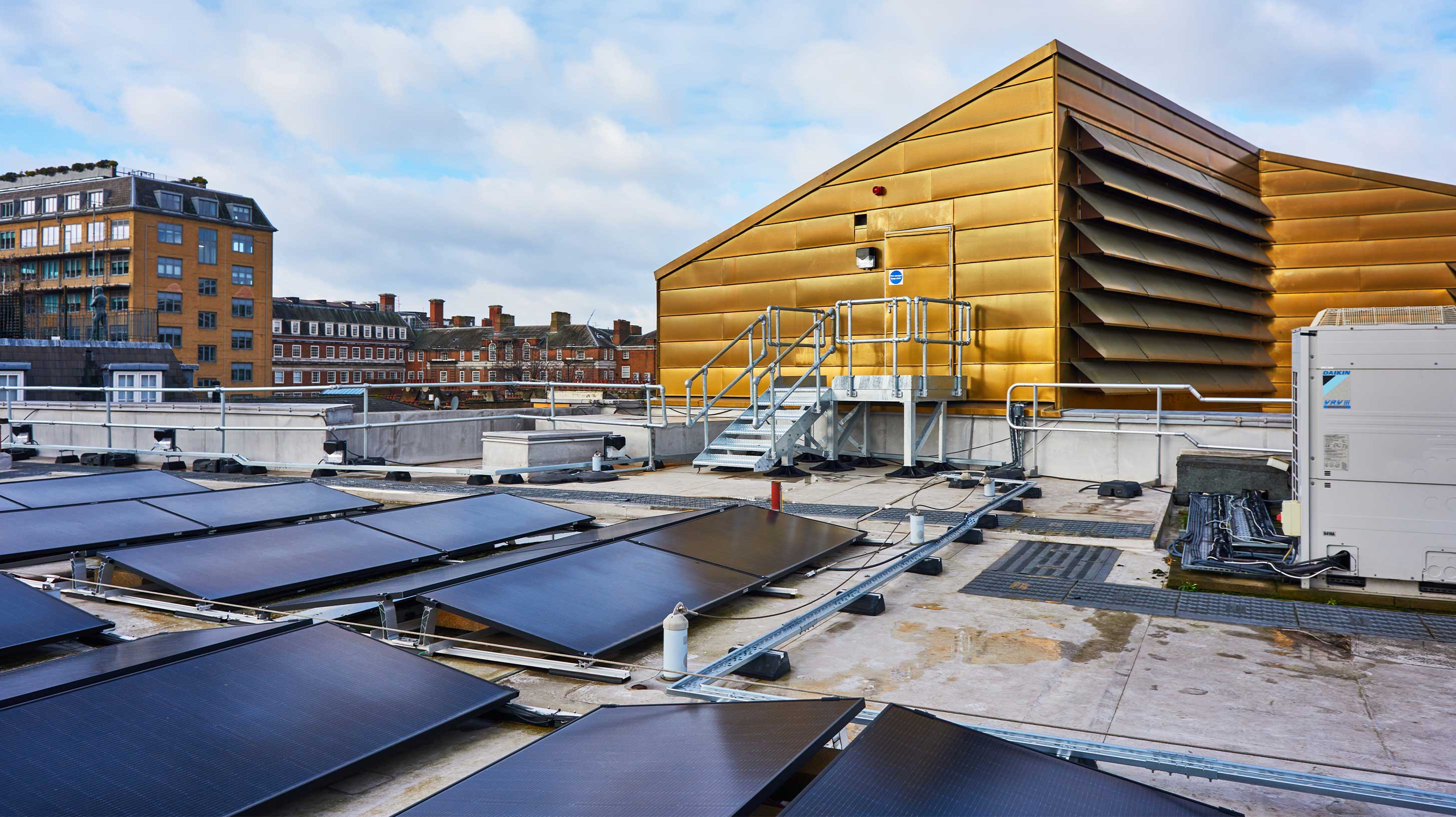 Modern architectural building rooftop with array of solar panels to provide environmental benefits