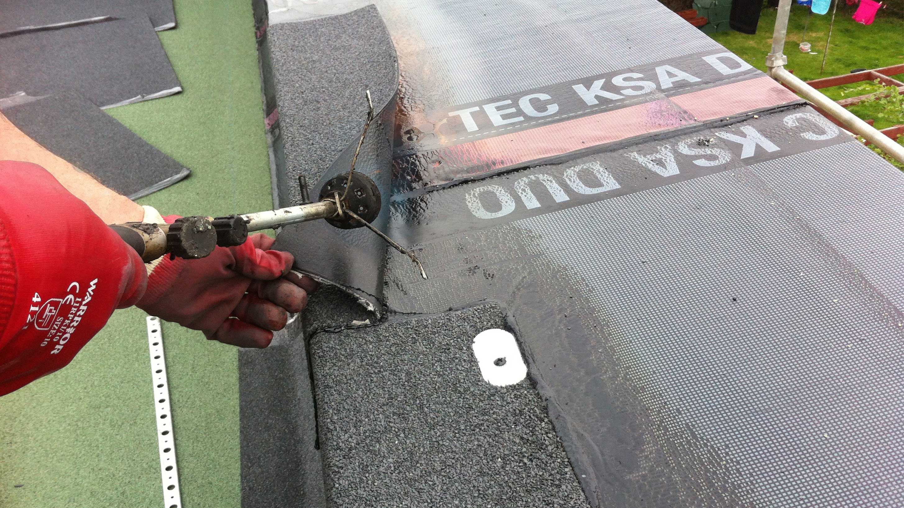 Man with blow torch installing hot melt product