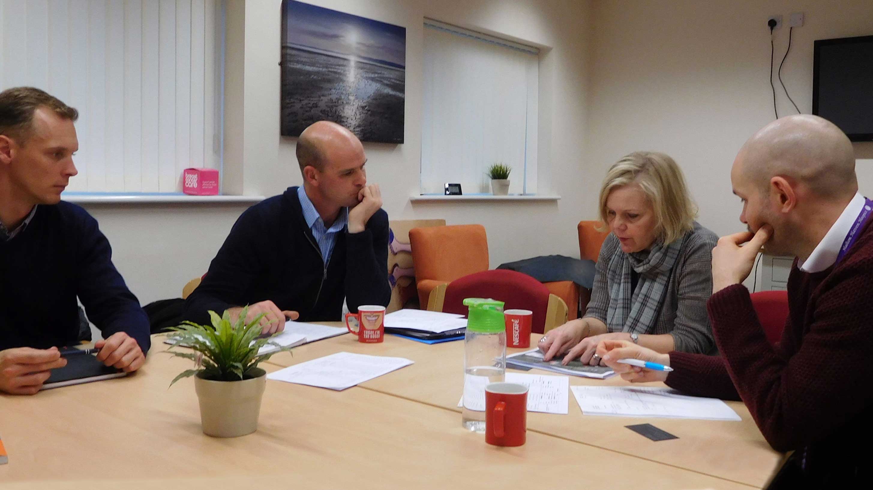 4 people discussing in a room