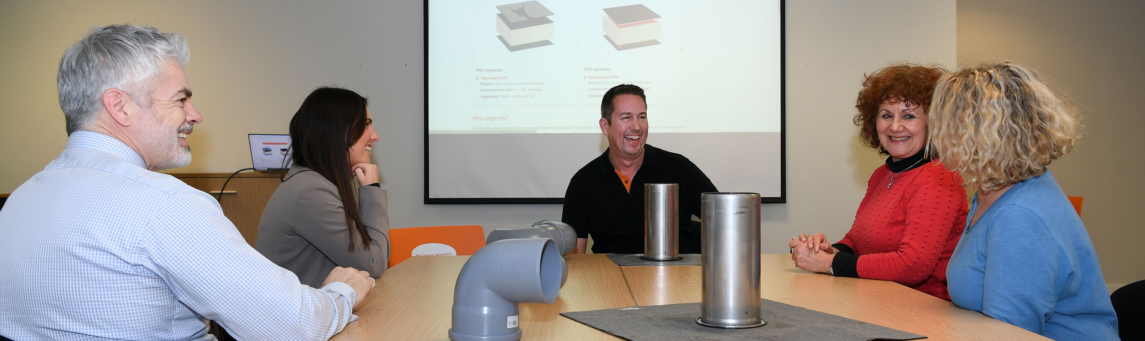 a group of people discussing bauder products laid on a table