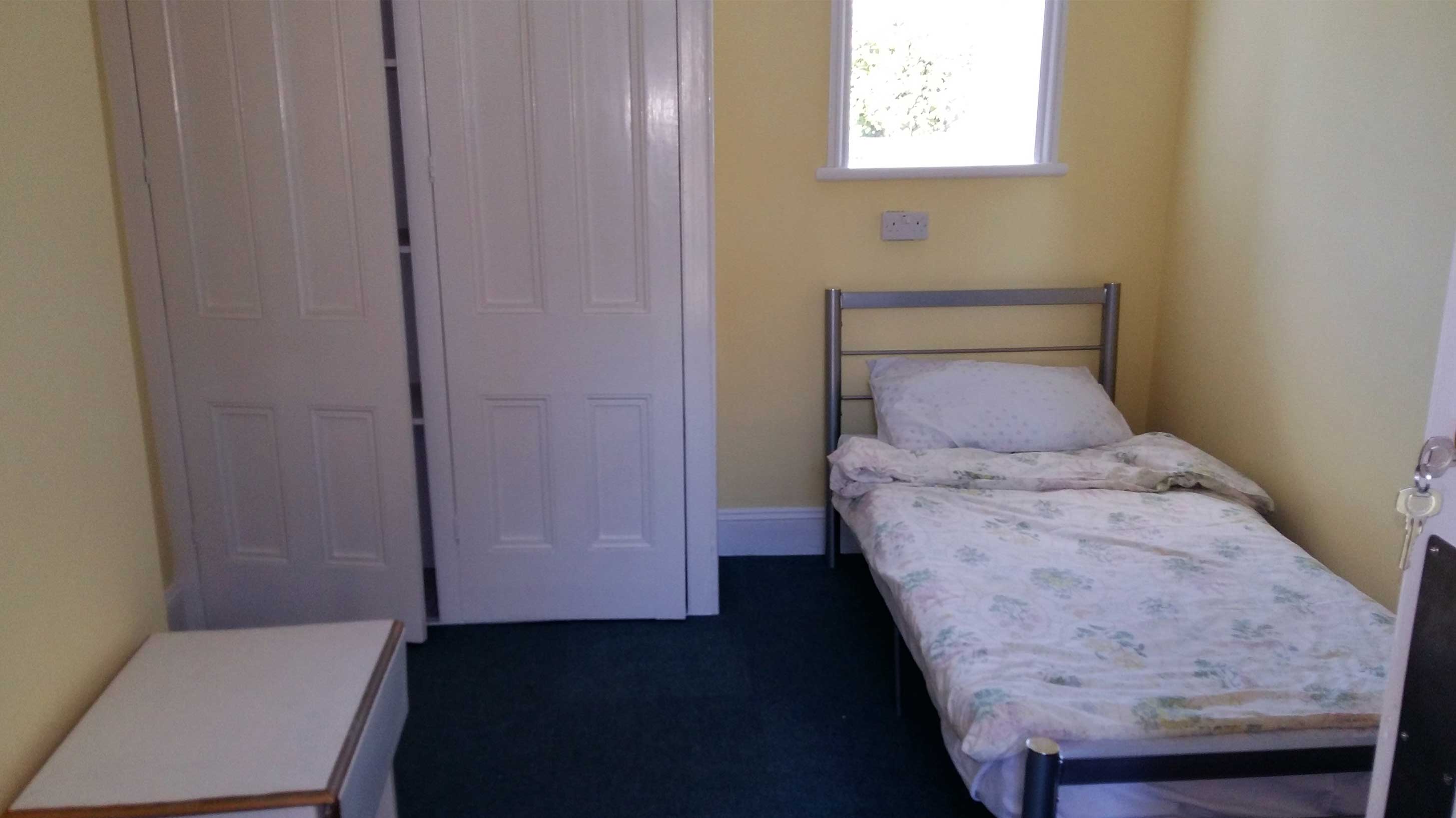 Emmaus Brighton charity project house room with single bed and wardrobe