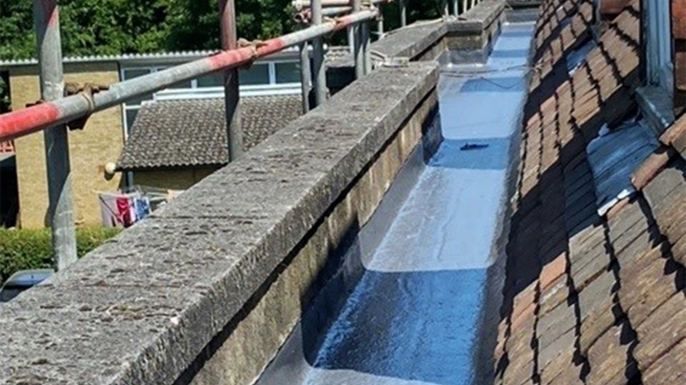 Bituminous waterproofing system shown with scaffolding in background