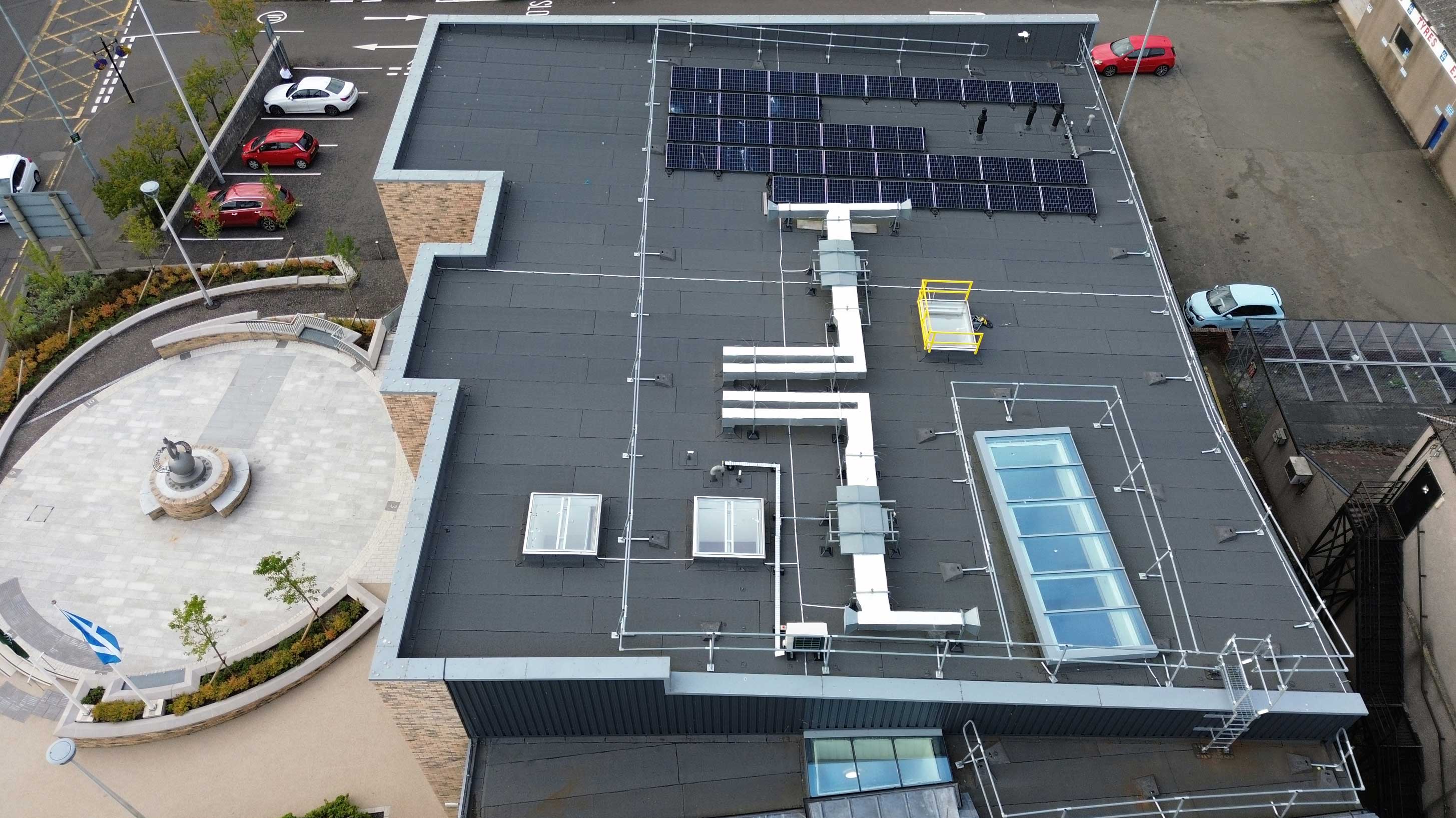 Modern building, Whitburn Partnership Centre, rooftop shown with array of solar panels on Bauder total roof system with rooflights