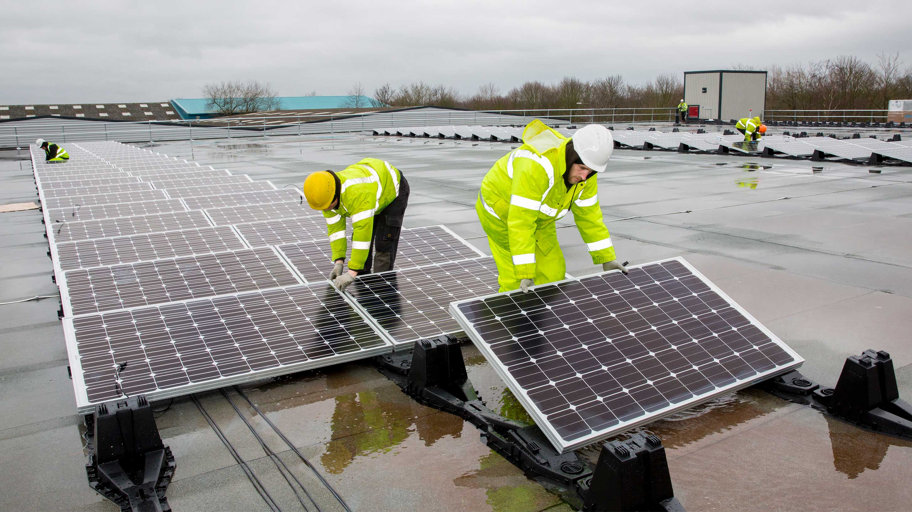 Rooftop with 2 men installing Array of solar panels